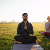 front-view-man-woman-meditating-outdoors_23-2148988366