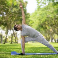 Inspired Indian man doing yoga asanas in city park